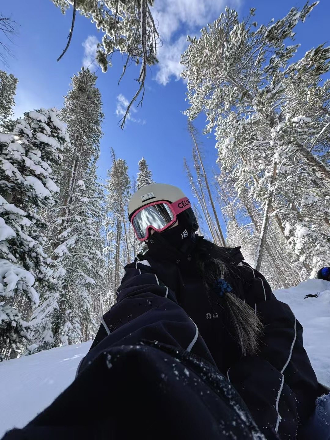 Snowboarding selfie under snow-covered pines and blue sky
